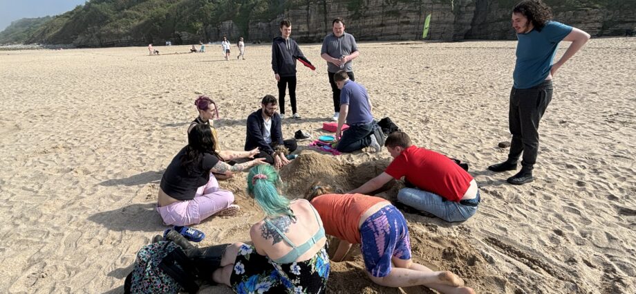 a group of community members enjoying the beach in the late afternoon